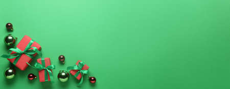 Gift boxes and Christmas balls on green background with space for textの写真素材