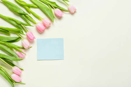 Beautiful flowers and empty card on white backgroundの写真素材