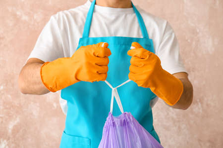Janitor with garbage on color backgroundの写真素材