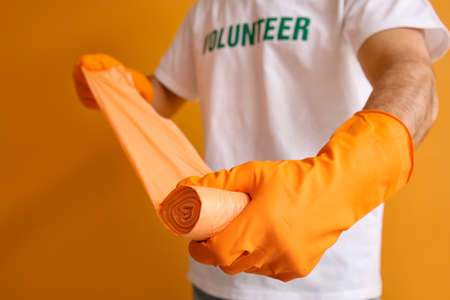 Volunteer with garbage bags on color backgroundの写真素材