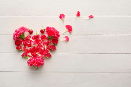 Heart made of beautiful flowers on wooden backgroundの写真素材