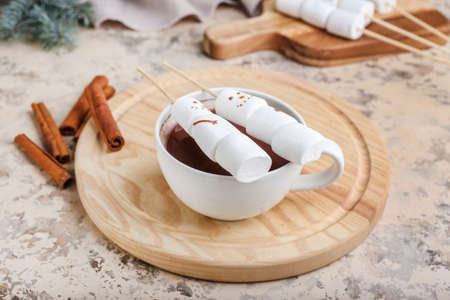 Snowmen made of soft marshmallows and cup of hot chocolate on grunge backgroundの写真素材