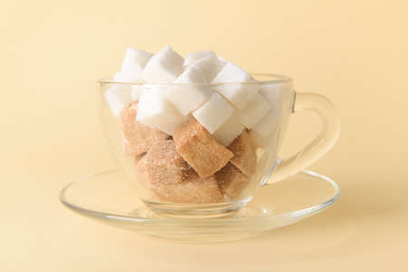 Cup with sweet sugar on color backgroundの写真素材