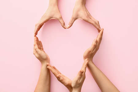 Hands making heart on color backgroundの写真素材