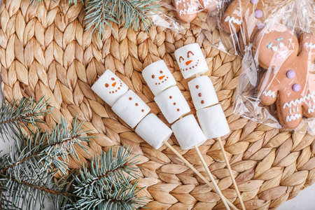 Snowmen made of soft marshmallows on wicker mat