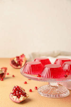 Dessert stand with tasty pomegranate jelly on color backgroundの写真素材
