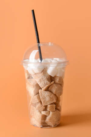 Cup with sweet sugar on color backgroundの写真素材