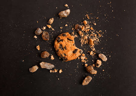 Tasty crunchy cookie with sugar on dark background