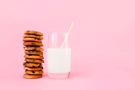 Tasty chocolate chips cookies with milk on color backgroundの写真素材