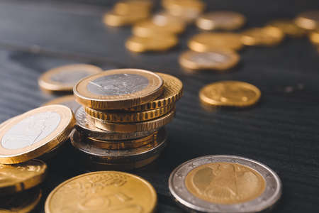 Golden coins on dark wooden background