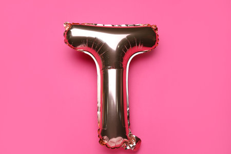 Balloon in shape of letter T on pink backgroundの写真素材