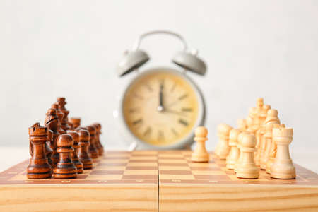 Chess board and alarm clock on white backgroundの写真素材