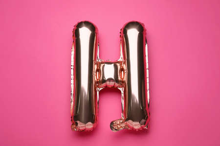 Balloon in shape of letter H on pink background