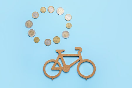 Small bicycle with coins on color background