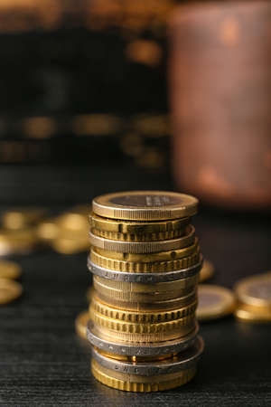 Golden coins on dark wooden background