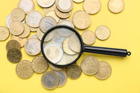 Magnifier with coins on color backgroundの写真素材