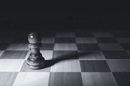 Chess board with pawn on dark backgroundの写真素材