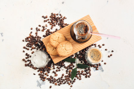 Pot and cup with delicious turkish coffee and cookies on light backgroundの写真素材