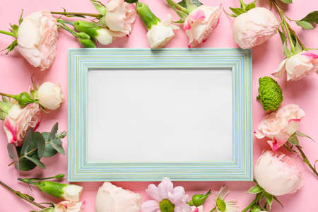 Beautiful flowers and blank frame on color backgroundの写真素材