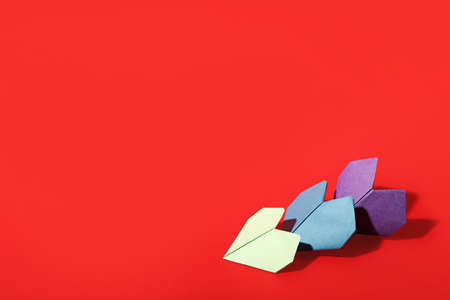 Origami hearts on color background