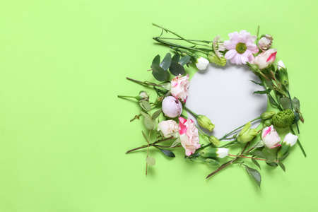 Beautiful flowers and blank card on color backgroundの写真素材