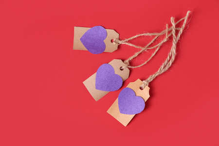Shopping tags with paper hearts on color backgroundの写真素材