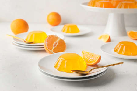 Plates with tasty orange jelly on white backgroundの写真素材