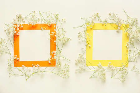 Beautiful flowers and blank frames on light backgroundの写真素材