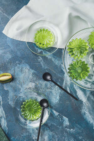 Plates with tasty kiwi jelly on color backgroundの写真素材