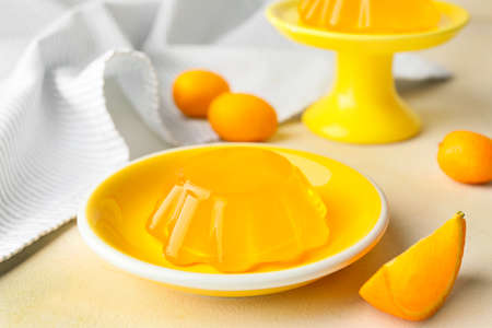 Plate with tasty orange jelly on white backgroundの写真素材