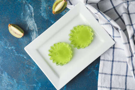 Plate with tasty kiwi jelly on color backgroundの写真素材