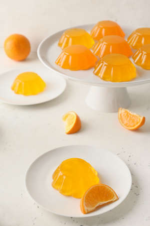 Plates with tasty orange jelly on white backgroundの写真素材