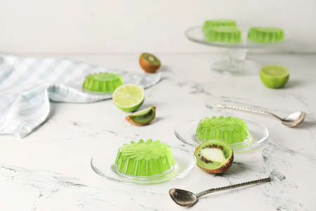 Plates with tasty kiwi jelly on light backgroundの写真素材