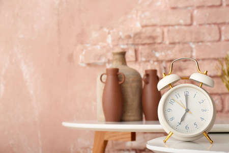 Alarm clock on table near color brick wallの写真素材