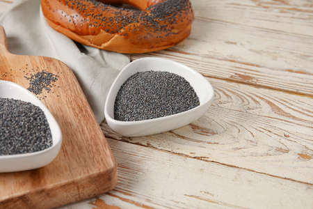 Bowls with poppy seeds on light wooden backgroundの写真素材