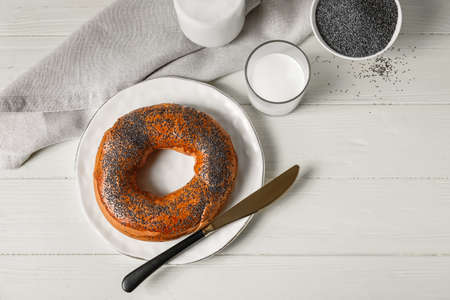 Bagel with poppy seeds on light wooden backgroundの写真素材