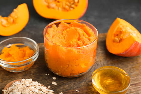 Composition with pumpkin body scrub and ingredients on dark backgroundの写真素材