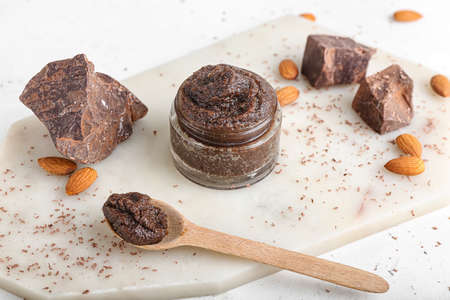 Jar of chocolate body scrub and ingredients on light backgroundの写真素材