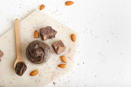 Jar of chocolate body scrub and ingredients on light backgroundの写真素材