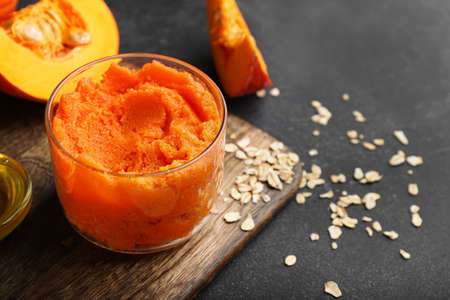 Composition with pumpkin body scrub and ingredients on dark backgroundの写真素材