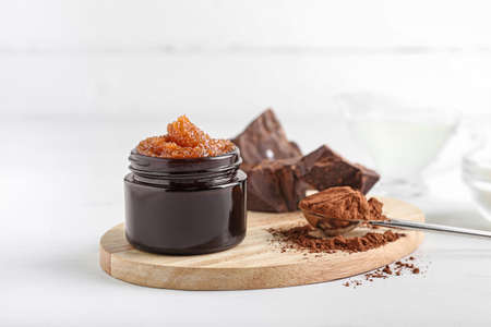 Jar of chocolate body scrub and ingredients on light backgroundの写真素材