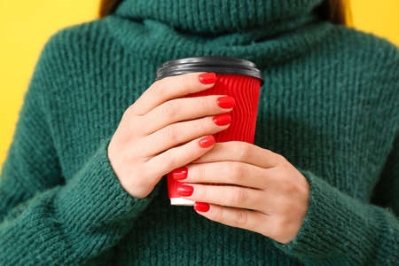 Young woman with beautiful manicure and coffee on color background, closeupの写真素材