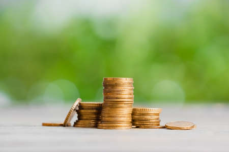 Heap of golden coins on table outdoorsの写真素材