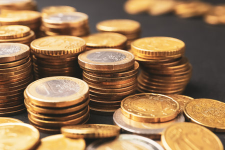 Heap of golden coins on dark background, closeup