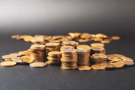 Heap of golden coins on dark backgroundの写真素材