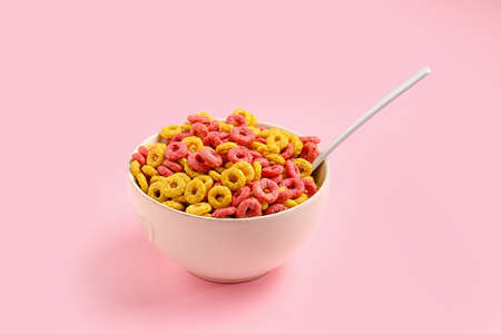 Bowl and spoon with crispy cereal rings on color backgroundの写真素材