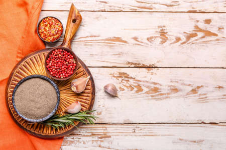 Board with different types of pepper on white wooden backgroundの写真素材