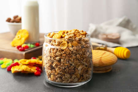 Glass jar with tasty granola on tableの写真素材