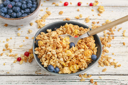 Plate with tasty granola on wooden background