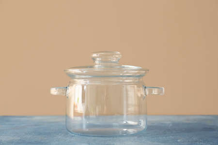 Stylish cooking pot on color background